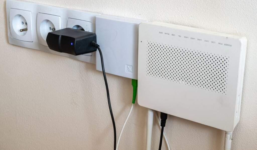 Prises électriques et modem internet sur fond de mur crème