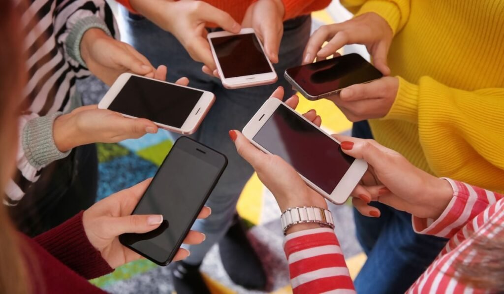 Jeunes avec des téléphones portables debout en cercle